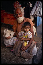 India, Orissa, General, Holy man with grand daughter with kohl painted on her forehead and around her eyes to ward off the evil eye.