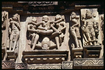 India, Madhya Pradesh, Khajuraho, Details of erotic stone carving on ancient temple exterior.