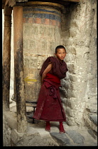 India, Ladakh, General, Child monk turning prayer wheel in monastery.