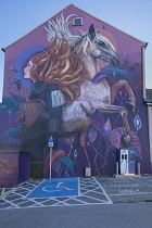 Ireland, County Wexford, New Ross, mural by Dutch artist Nina Valkhoff showing a Norman warrior woman and her horse towering 50 metres high above an electric car charging point.