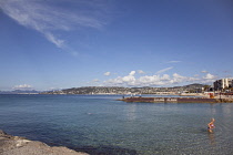 France, Provence-Alps, Cote d'Azur, Antibes Juan-les-Pins, Beach with tourists sunbathing and swimming in the sea.