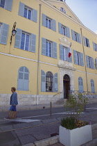 France, Provence-Alps, Cote d'Azur, Antibes, Exterior of the Hotel Deville a yellow coloured town hall building with blue shutters and flying the French Tricolour flag.