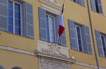 France, Provence-Alps, Cote d'Azur, Antibes, Exterior of the Hotel de Ville a yellow coloured town hall building with blue shutters and flying the French Tricolour flag.