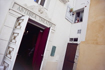 France, Provence-Alps, Cote d'Azur, Antibes, Entrance to the Antibea Theatre with old woman looking from window above.