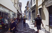 France, Provence-Alps, Cote d'Azur, Antibes, Narrow side street in the old town busy with shoppers.