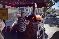 France, Provence-Alps, Cote d'Azur, Antibes, Cooking Socca an nicoise chickpea pancake in the Provencal food market.