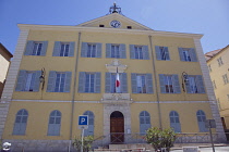 France, Provence-Alps, Cote d'Azur, Antibes, Exterior of the Hotel de Ville a yellow coloured town hall building with blue shutters and flying the French Tricolour flag.