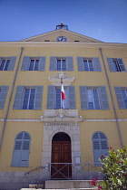 France, Provence-Alps, Cote d'Azur, Antibes, Exterior of the Hotel de Ville a yellow coloured town hall building with blue shutters and flying the French Tricolour flag.