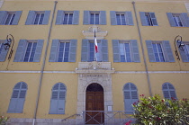 France, Provence-Alps, Cote d'Azur, Antibes, Exterior of the Hotel de Ville a yellow coloured town hall building with blue shutters and flying the French Tricolour flag.