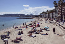 France, Provence-Alps, Cote d'Azur, Antibes Juan-les-Pins, Beach with tourists sunbathing and swimming in the sea.