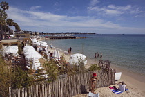 France, Provence-Alps, Cote d'Azur, Antibes Juan-les-Pins, Beach with tourists sunbathing and swimming in the sea.