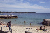 France, Provence-Alps, Cote d'Azur, Antibes Juan-les-Pins, Beach with tourists sunbathing and swimming in the sea.