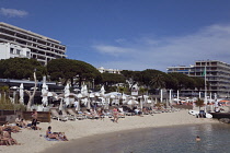 France, Provence-Alps, Cote d'Azur, Antibes Juan-les-Pins, Beach with tourists sunbathing and swimming in the sea.