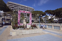 France, Provence-Alps, Cote d'Azur, Antibes Juan-les-Pins, Statue decorated with flowers on seafront.