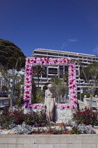 France, Provence-Alps, Cote d'Azur, Antibes Juan-les-Pins, Statue decorated with flowers on seafront.