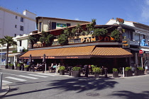 France, Provence-Alps, Cote d'Azur, Antibes Juan-les-Pins, People sat outside cafe bar eating and drinking.