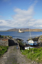 Scotland, Outer Hebrides, Isle of Barra, Castle Bay, Kisimul castle seen from the shore with moored boats in the foreground.