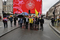 England, London, Picadilly Circus, Sikh family celebrating the coronation of King Charles III on a rainy May 6th 2023.