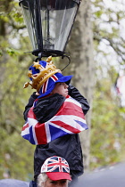 England, London, The Mall,  Young boy climbing lamp post to get better view of the coronation of King Charles III on a rainy May 6th 2023.