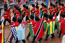 England, London, The Mall, Grenadier Guards marching with flags from the commonwealth countries during the coronation of King Charles III on a rainy May 6th 2023.