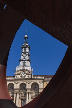 Spain, Basque Country, Bilbao, City Hall in the Baroque style dating from 1892 viewed through a sculpture by Jorge Oteiza in front of the building.