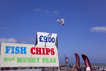 England, East Sussex, Brighton, Sign on fast food outlet in the seafront promenade busy with summer tourists.