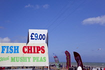 England, East Sussex, Brighton, Sign on fast food outlet in the seafront promenade busy with summer tourists.