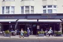 England, East Sussex, Brighton, Hove, Western Road, People sat eating and drinking outside the Six restaurant.