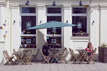 England, East Sussex, Brighton, Hove, Western Road, People sat outside T@Hove cafe.