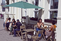 England, East Sussex, Brighton, Hove, Western Road, People sat outside T@Hove cafe.