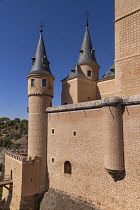 Spain, Castile and Leon, Segovia, 12th century Alcazar of Segovia with a view of some of the turrets on the 15th century Tower of John 2nd of Castile seen from the Plaza de la Reina Victoria in front of the fortress..