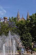 Spain, Balearic Islands, Majorca, Palma de Mallorca, Old Town. Royal Palace of La Almudaina and La Seu Gothic Roman Catholic Cathedral of Santa Maria with fountain in the foreground.