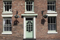 England, Shropshire, Ironbridge, Exterior of traditional house with hangin flower baskets.