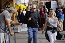 England, London, Homeless man with crutches begging in the street.