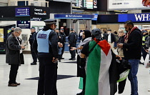 England, London, Charring Cross Station, Police Liasion officers engage with Palestinian supporters and ask them to remove the Palestinian flag or they may be in breach of a public order offence.