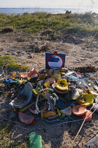Iceland, Snaefellsnes Peninsula National Park, Ytri Tunga seal beach with sightseeing tourists. Do not liteer sign with assorted litter collected from beach.