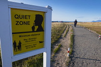 Iceland, Snaefellsnes Peninsula National Park, Ytri Tunga seal beach with sightseeing tourists. Quiet Zone sign.