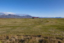 Iceland, Snaefellsnes Peninsula National Park, Arable farm and fields. With snow capped mountains in the distance.
