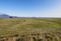 Iceland, Snaefellsnes Peninsula National Park, Arable farm and fields. With snow capped mountains in the distance.