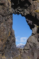 Iceland, Snaefellsnes Peninsula National Park, Snaefellsjokull, a 700,000-year-old glacier-capped stratovolcano seen through a window in the volcanic formation.