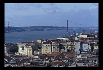 Portugal, Lisbon, April 25th Bridge with rooftops in the foreground.