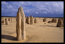 Australia, Western Australia, Nambung National Park, The Pinnacles Desert. Flat sandy range with limestone pillars leading in to the distance.