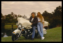 USA, Young couple and their Harley Davidson motorcycle.