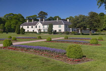 Ireland, County Kerry, Killarney, Killarney House and Gardens, ornamental gardens with Killarney House in the background.