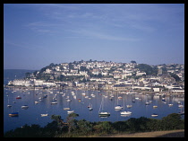 Wales, Dyfed, Tenby, View over harbour and moored boats at low tide with harbour wall and nearby buildings behind.