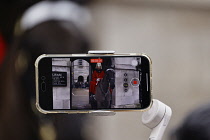England, London, Westminster, Whitehall, member of the Household Cavalry on horseback being recorded on mobile phone.