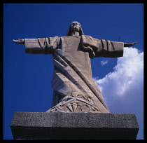 Portugal, Madeira, Garajau, View from below of a statue of Christ against a blue sky.