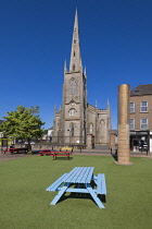 Republic of Ireland, County Monaghan, Monaghan town, Church Square, St Patrick's Church of Ireland with the Monaghan Memorial which is a sandstone and metal pillar erected in front of the courthouse i...