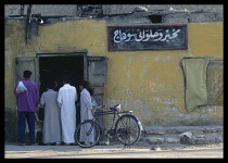 Egypt, Western Desert, Siwa Oasis, Group of men at Bakery with yellow coloured walls.