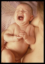 Health, Children, Moods, One month old baby girl held in her mothers arms and crying.